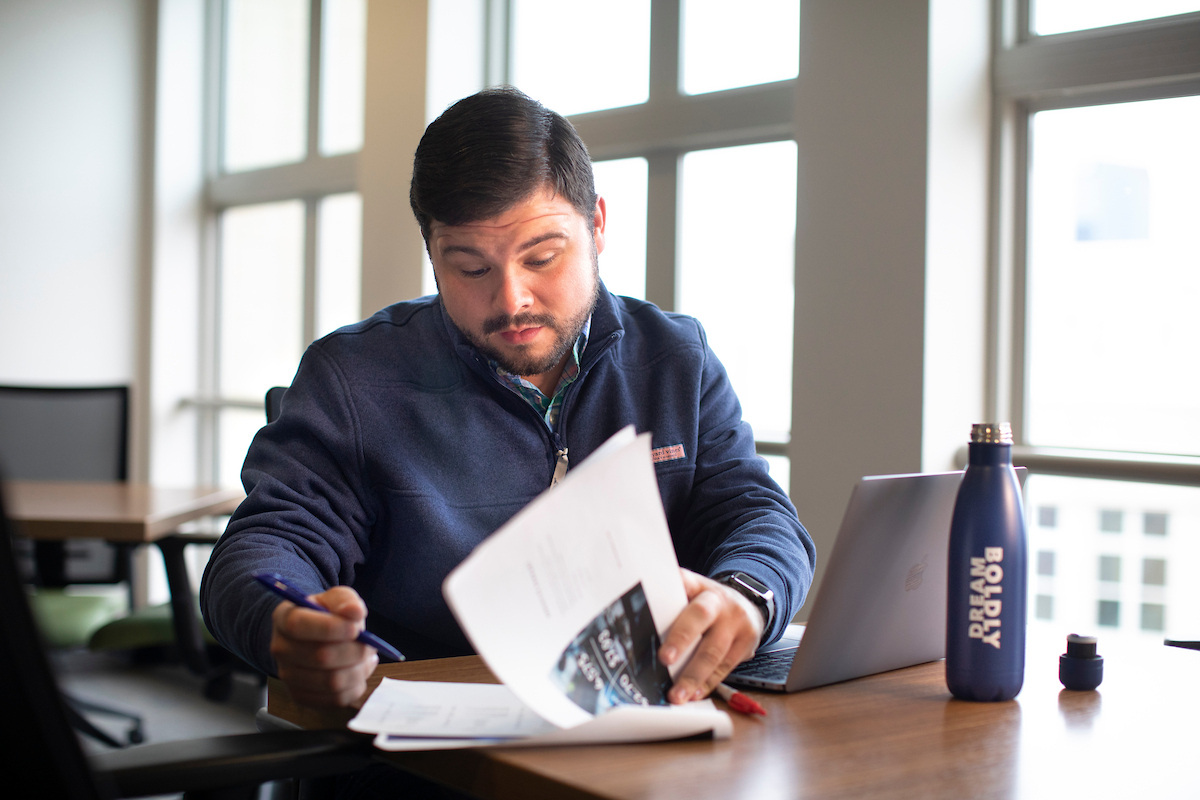 online student looking at work with water bottle