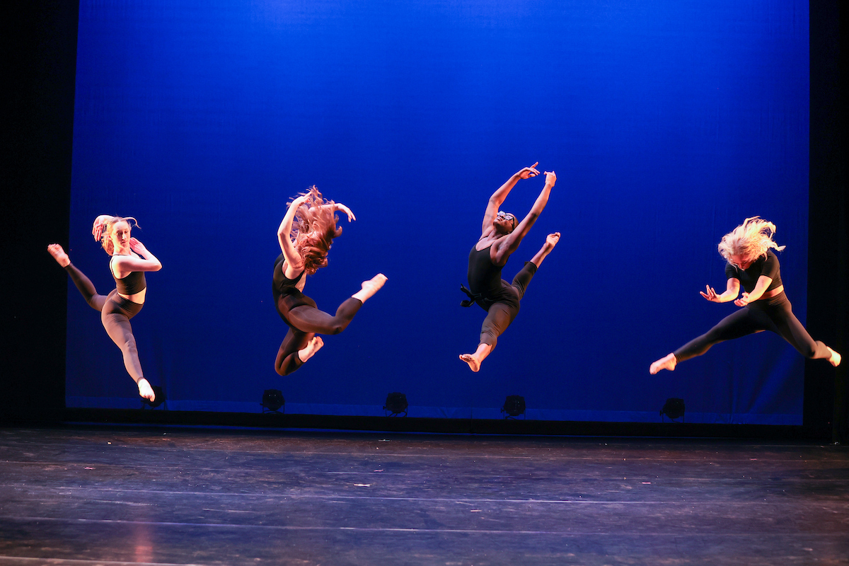dancers on stage jumping in the air