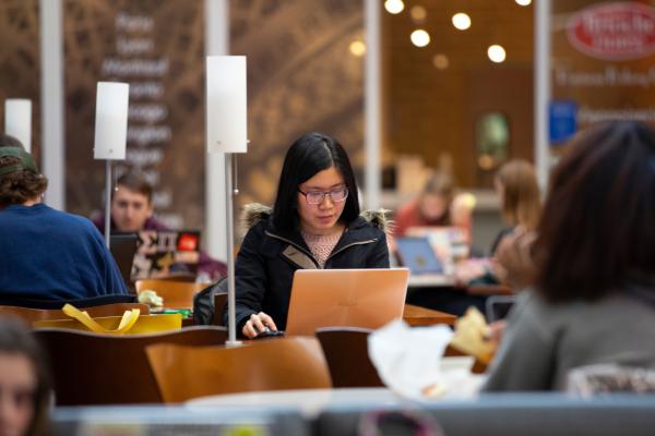 online student working on laptop library
