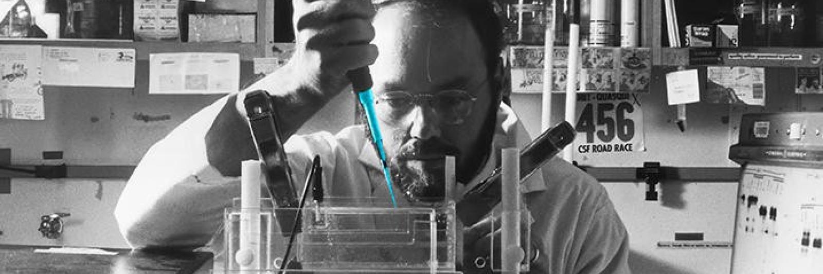 TEXT Cracking the Code IMAGE: person in lab