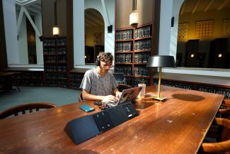 student studying in library with headphones