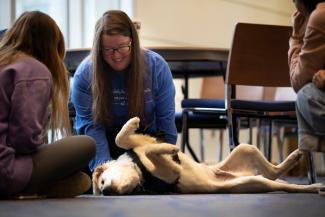 student petting dog