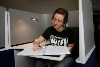 IMAGE: Student working at desk with notebook