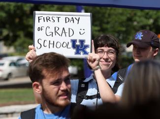 first day of grad school student holding sign with UK logo 