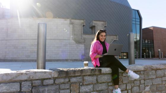 student on laptop smiling