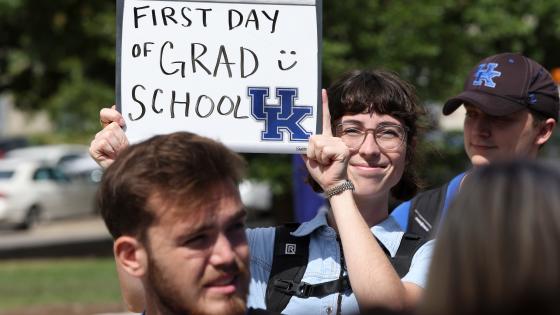 first day of grad school student holding sign with UK logo 