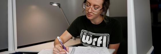IMAGE: Student working at desk with notebook